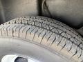 A close-up of a tire showcasing detailed tread patterns and sidewall markings of a 1976 GMC Palm Beach