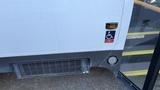 A 2021 Ford Transit with a wheelchair accessibility button and a warning sign to watch your step near the entrance