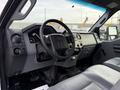 Interior view of a 2015 Ford F-350 showing the dashboard steering wheel and center console with various controls and a leather seat