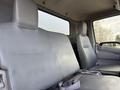 Interior view of a 2014 Hino 195 featuring two gray fabric seats with seatbelts and a simple dashboard design