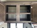 An empty wooden cabinet with four compartments and metal hinges in a 2021 Jayco Jay Flight