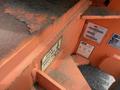 A close-up view of a 2009 JLG E300AJP lift with worn orange metal showing labels and specifications including weight limits and operational instructions