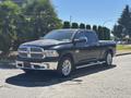 A 2015 RAM 1500 pickup truck in black with chrome accents parked on a street