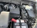 Close-up view of the engine compartment of a 2018 Toyota Highlander showing various components including the battery air intake and coolant reservoir