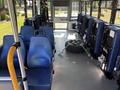 Interior of a 2020 Chevrolet Express featuring blue seats and a spare tire secured in the middle aisle