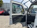 A 2010 Daihatsu Hijet with an open driver-side door showcasing the interior features including the dashboard and seating area