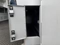 A partially open compartment door on a 2020 Mercedes-Benz Sprinter 2500 revealing an empty storage space inside