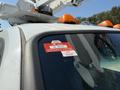 A 2008 Ford F-550 with an orange beacon light on top and a certificate of approval sticker on the windshield