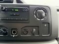 Dashboard of a 2013 Ford Econoline featuring audio controls and knobs for adjusting volume and input settings