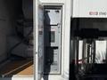 A 2011 Freightliner M2 106 with an open side compartment revealing electrical controls and a warning sign about danger