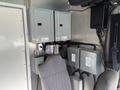 Interior view of a 2020 Freightliner MT45 showing two electrical control boxes mounted on the wall next to a grey driver seat and various wiring
