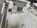 Close-up of the inner side of a utility truck with danger signs and a metal edge visible on a weathered surface