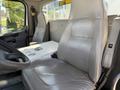 Interior of a 2010 Freightliner M2 106 with two gray leather seats and a central console featuring storage compartments