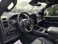 Interior of a 2021 RAM 1500 showcasing a modern dashboard leather-wrapped steering wheel and a large touchscreen display