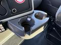 A close-up of the cup holder in a 2010 International 4300 truck's interior featuring a circular cup section and a round insert for stabilizing drinks