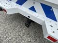 A 2017 Chevrolet Colorado truck with a tow hitch attached on the rear bumper featuring a white and blue striped design
