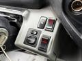 Close-up of the control panel in a 2015 Hino 195 with buttons for heating, a mirror adjustment knob, and two red light indicators