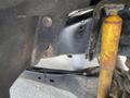 Close-up of a 2015 Ford F-550 chassis showcasing a suspension component and a yellow shock absorber with visible wear and rust