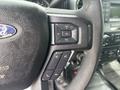 Close-up of the steering wheel of a 2017 Ford F-150 showing buttons for volume control and media functions
