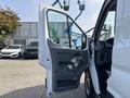 A 2016 Ford Transit 150 with the front door open showing the interior and driver's seat