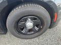 Close-up of the wheel of a 2015 Dodge Charger featuring a black rim and a worn all-season tire