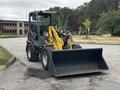 A 2014 Wacker Neuson WL34 compact wheel loader with a yellow bucket attachment facing forward at an outdoor location