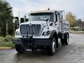 A 2011 International WorkStar truck with a white exterior and a dump bed visible in the rear showcasing a robust front grille and headlights