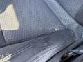 Interior close-up of a 2006 Pontiac G6 seat showing textured fabric with a small spot and some dust along the seam