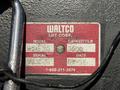 A weathered metal plate displaying information about a WALTCO lift including model number capacity and serial number