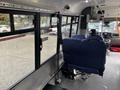 Interior view of a 2021 Ford Transit-350 showing two blue seats and windows with a safety strap visible on one seat