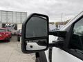 A close-up of the side mirror of a 2020 Ford F-550 showing a reflective surface with a partial view of the truck's body and surrounding vehicles in the background