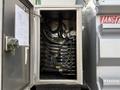 A metal control box containing multiple hydraulic hoses and valves along with a pressure gauge visible inside an open compartment