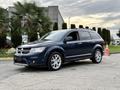 A blue 2013 Dodge Journey with a sleek design featuring alloy wheels and a spacious interior