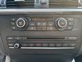 The image features the control panel of a 2013 BMW X3 with climate control knobs temperature display and radio controls