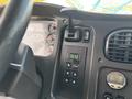 The interior dashboard of a 2013 Freightliner 114SD featuring gauges a gear shifter buttons for transmission control and an electronic display for vehicle settings
