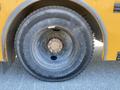 Close-up of a worn tire on a yellow 2006 Thomas Saf-T-Liner HDX bus showing visible treads and a rusted rim