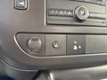 Control panel of a 2023 GMC Savana featuring buttons for various functions and a central dial for media or climate control