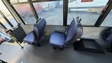 Two blue upholstered bus seats are positioned next to each other in the foreground