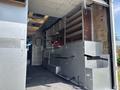 A 2011 Workhorse W62 interior featuring metal shelving and a work counter designed for utility use