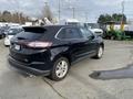 A 2017 Ford Edge parked, showing its sleek design, dark exterior, and distinctive rear profile with a modern look and alloy wheels
