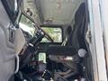 The interior of a 2008 Peterbilt 340 featuring a steering wheel a driver's seat with black upholstery and various controls on the dashboard