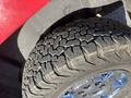 Close-up of a rugged tire from a 2011 Chevrolet Avalanche showcasing deep tread patterns and shiny chrome alloy rim