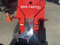 Red industrial snow removal machine with a wide front blade and rubber tracks labeled SDA-140T(Z)