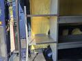 A 2016 Ford Transit 150 with metal shelving securely mounted in its cargo area