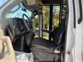 Interior view of a 2020 Chevrolet Express featuring a driver’s seat and steering wheel with dashboard controls visible