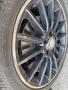 Close-up of a black alloy wheel with a Mercedes-Benz logo showcasing brake calipers and tires with tread patterns