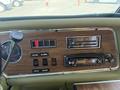 Dashboard of a 1976 GMC Motorhome featuring a radio, various gauges, buttons for fuel and air, and a wooden panel finish