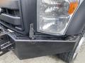 A 2015 Ford F-550 with a prominent front grille and a large bumper featuring a tow hook and a fog light on one side