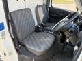 Interior of a 2008 Suzuki Carry showing two gray cloth seats and a steering wheel
