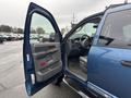 A blue 2006 Dodge Ram 2500 with an open driver's side door revealing the interior dashboard and seating area